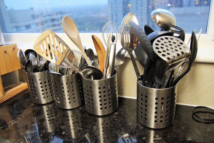 Kitchen tools in metallic glasses on table